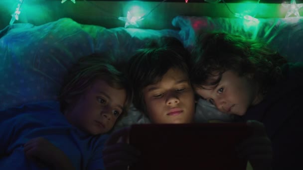 Group Kids Laying Together Bed Using Digital Table Screen Illuminates — Stock Video