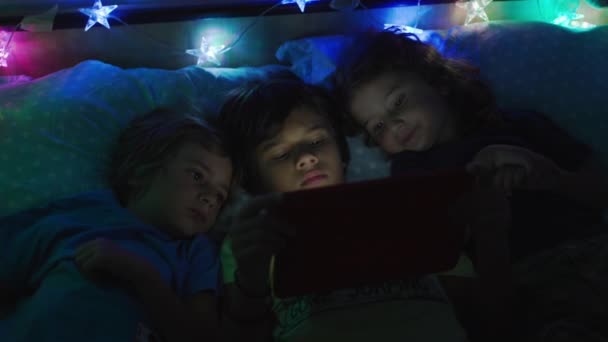 Група Дітей Лежать Разом Ліжку Використовують Цифровий Стіл Екран Освітлює — стокове відео