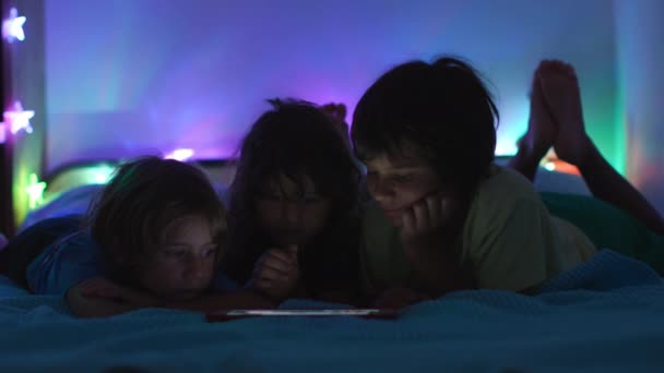 Dijital Ekranın Parıltısı Altında Çocuk Bir Yatağa Uzanır Gece Boyunca — Stok video