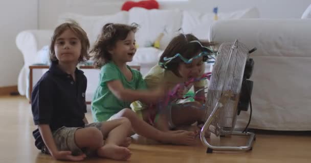 Trójka Dzieci Siedzi Podłodze Salonie Środkowe Dziecko Zabawnie Przemawia Elektrycznego — Wideo stockowe