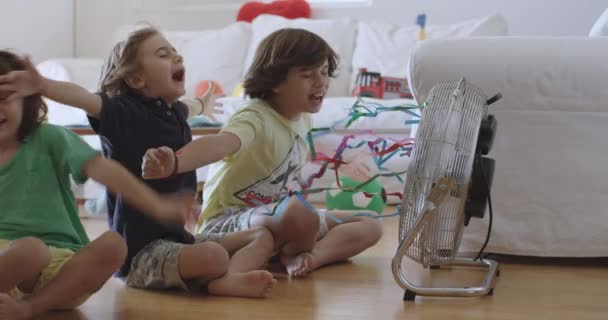 Três Meninos Estão Ajoelhados Chão Casa Apreciando Brisa Ventilador Elétrico — Vídeo de Stock