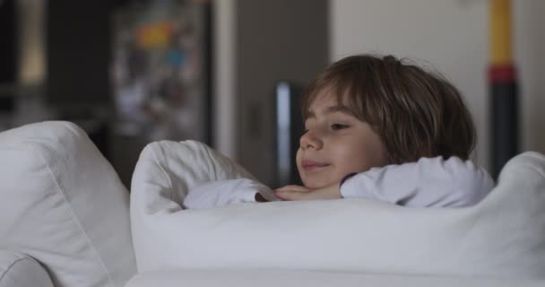 Contemplative Young Boy Rests His Chin His Hands While Reclining — Stock Video