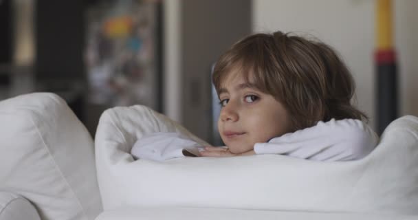 Băiat Contemporan Își Sprijină Bărbia Mâini Timp Așează Canapea Albă — Videoclip de stoc