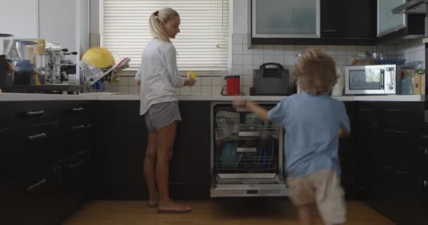 Una Madre Sta Accanto Alla Lavastoviglie Una Cucina Sorvegliando Suoi — Video Stock