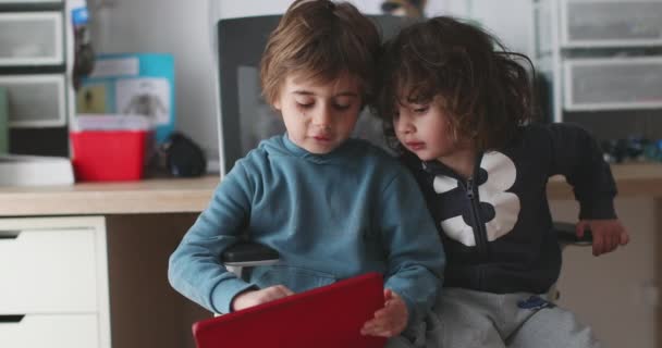 Два Маленьких Мальчика Сидят Близко Друг Другу Сосредоточившись Цифровом Планшете — стоковое видео