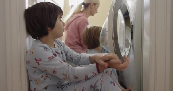 Mother Supervises Her Young Kids Dressed Pajamas Watch Clothes Spin — Stock Video