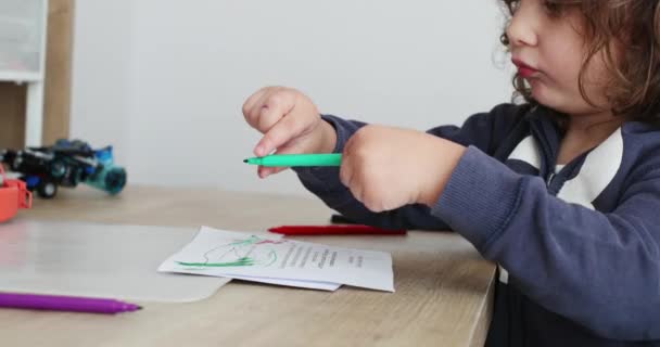 Ein Kleiner Junge Konzentriert Sich Beim Zeichnen Mit Einem Grünen — Stockvideo
