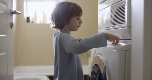 Young Boy Blond Hair Standing Front Washing Machine Sunlight Filtering — Stock Video