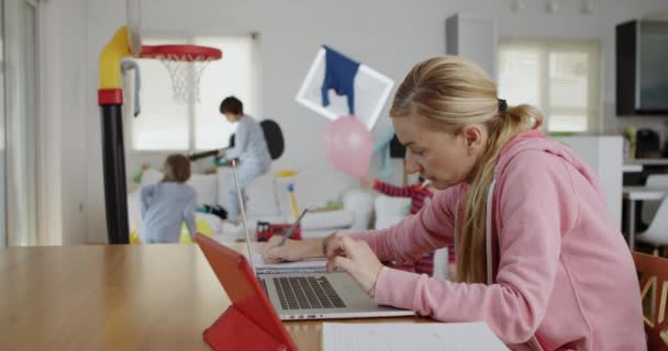 Uma Mãe Focada Uma Camisola Rosa Trabalha Remotamente Seu Laptop — Vídeo de Stock