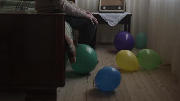 Elderly Gentleman Sits Pensively Bed Radio Surrounded Vibrant Balloons Suggesting — Αρχείο Βίντεο
