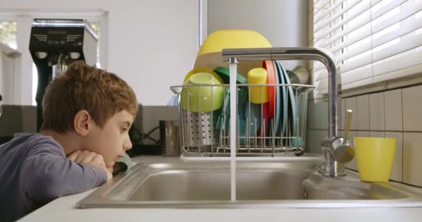 Curious Young Boy Closely Observing Stream Water Flowing Modern Kitchen — Stockvideo