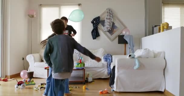 Three Kids Energetically Jumping White Couch Surrounded Toys Household Items — Stok Video