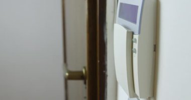 Bir adamın eli, güvenlik ve güvenliği sağlamak için duvarlara monte edilmiş bir tuş takımına alarm yerleştirirken yakalanır..