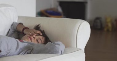 Huzurlu genç bir çocuk kanepede rahat bir şekilde kestiriyor.