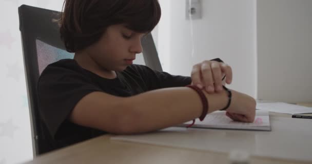 Мальчик Наклоняется Над Своим Столом Погруженный Домашнюю Работу Ручками Бумагами — стоковое видео