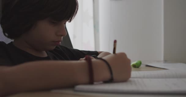 Young Boy Leans His Desk Engrossed His Homework Pens Papers — Vídeo de stock
