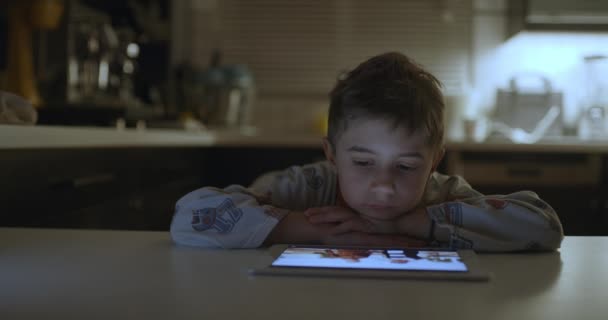 Young Boy Focuses Intently Digital Tablet While Resting His Chin — Stok video