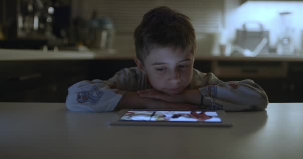 Young Boy Focuses Intently Digital Tablet While Resting His Chin — Vídeo de stock