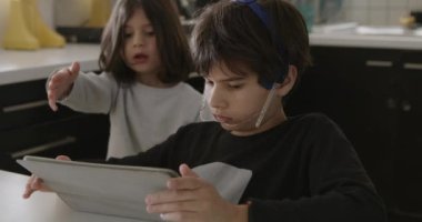 Elinde tuttuğu dijital tablet üzerinde yoğunlaşan diş teli olan genç bir çocuğun yakın çekim görüntüsü, muhtemelen eğitici bir aktiviteye veya dijital bir eğlenceye bağlanıyor..