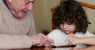 Yaşlı bir adam, genç torununa akıllı bir telefonun nüanslarında rehberlik eder ve evde birlikte kaliteli zaman geçirirler..