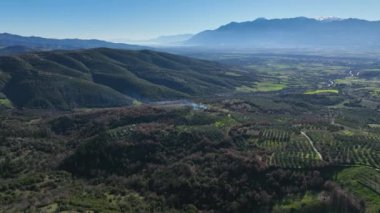 Sabahın erken saatlerinde sis kaplı dağların büyüleyici hava manzarası. Bulutlar yavaşça sarp, kayalık araziyi ve sık ormanları örterek dingin ve mistik bir atmosfer yaratıyor..
