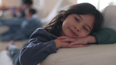Genç bir çocuk neşeyle gülümsüyor, battaniyeye sarılıp, gün boyunca kanepede dinleniyor..
