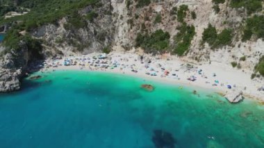 Yunanistan 'ın Lefkada kentinde turkuaz su ve güneş banyosu yapan güzel bir plaj manzarası..