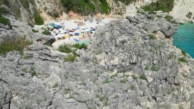 Yunanistan 'ın Lefkada kentinde turkuaz su ve güneş banyosu yapan güzel bir plaj manzarası..