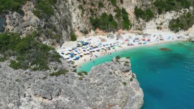 Yunanistan 'ın Lefkada kentinde turkuaz su ve güneş banyosu yapan güzel bir plaj manzarası..