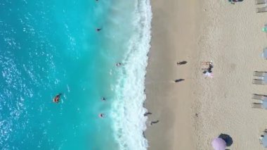 Yunanistan 'ın Lefkada kentindeki Kathisma Sahili' nin hava manzarasında el değmemiş beyaz kum, turkuaz sular, şemsiye ve güneş banyosu sıraları sergileniyor.
