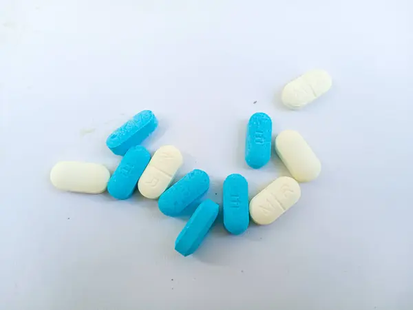 Beyaz üzerine izole edilmiş mavi ve beyaz ilaç haplarını kapat.