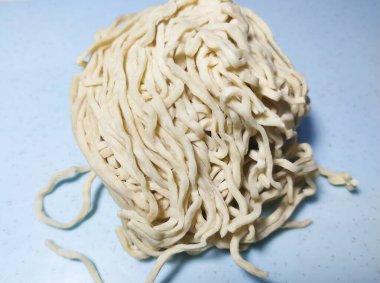 Mavi güvertede pişmemiş taze erişteli erişte. Seçici odak