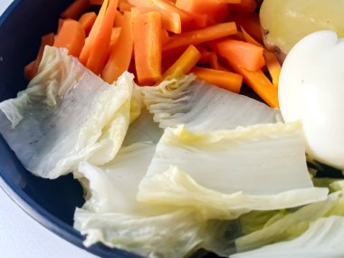 Siyah tabakta sebze ve tavuk salatası.