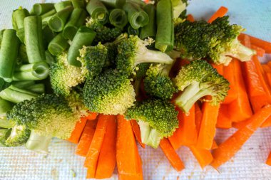 Pişmeye hazır taze çiğ sebzeler, havuç, brokoli ve fasulye.