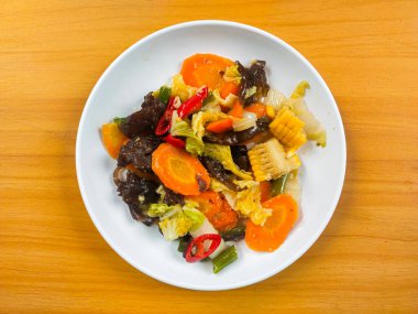 Kızarmış sebzeleri (Capcai veya capcay) beyaz tabakta karıştır. Havuç, mantar, lahana ve hardal. Endonezya yemekleri