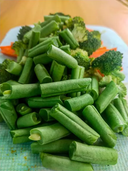 Pişmeye hazır taze çiğ sebzeler, havuç, brokoli ve fasulye.
