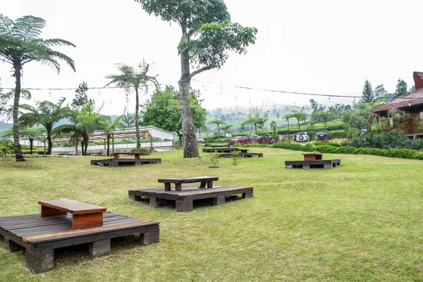 Arkaplanda sandalye ve masalar olan ahşap masa.