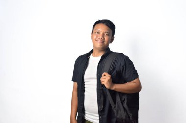 Sırt çantası taşıyan mutlu Asyalı genç adam gülümsüyor ve başka tarafa bakıyor. beyaz arkaplanda izole.