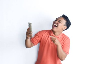 Mutlu Asyalı adam gülümsüyor ve beyaz arka planda izole edilmiş cep telefonu kullanıyor.