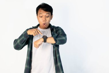 Saatine bakarken şok olmuş suratlı Asyalı bir adam.