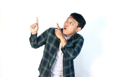 Yeşil tişörtlü Asyalı adamın şok olmuş yüzü sol elinde boş bir yeri işaret ediyor..