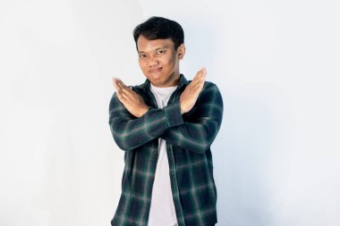 Yakışıklı Asyalı bir gencin portresi. Dur ya da Reddet ifadesini gösteriyor. Kollarını kavuşturuyor..