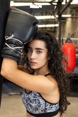 Seksi boksör boks çantasına birkaç kez vurduktan sonra kameraya bakıyor.