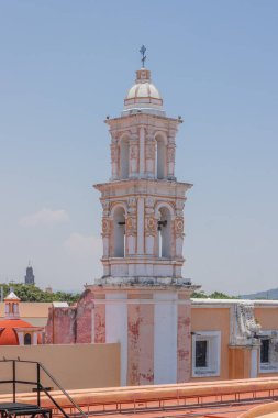 Pembe ve beyaz bir Meksika katedralinin kulesi. Mavi ve açık gökyüzü var..