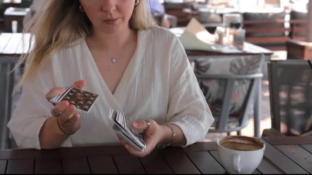 Młoda Piękna Blondynka Jasnym Stroju Czyta Karty Tarot Stole Kawiarni — Wideo stockowe