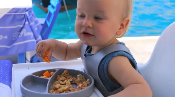 Baby Stuhl Isst Sein Essen Mit Den Händen Einem Restaurant — Stockvideo