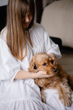 Cocker spaniel köpeği evde yerde sahibine sarılıp oynuyor. Sevimli evcil hayvan, en iyi arkadaşlar.