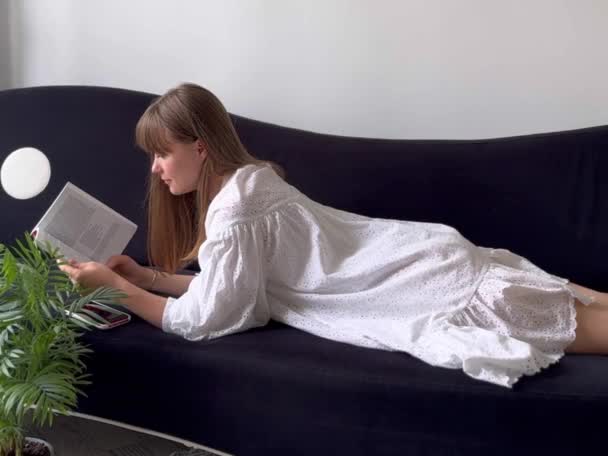 Kobieta Czyta Książkę Sofie Domu Odpocząć Zrelaksować — Wideo stockowe