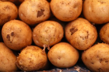 Pazar tezgahında taze patatesler, yakın plan.