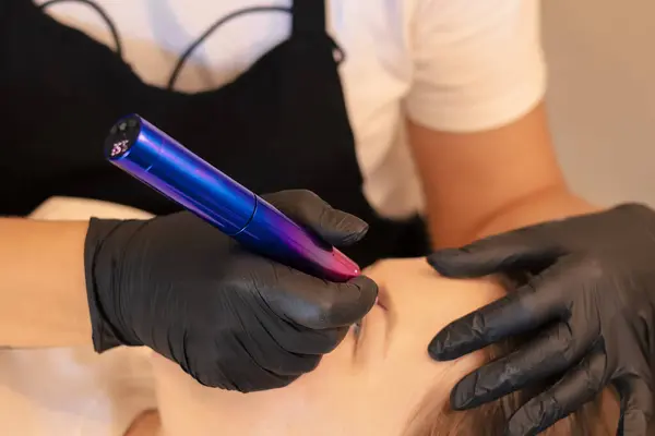 Dövme salonunda sürekli makyaj yapan genç bir kadın, yakın plan.